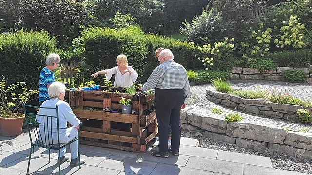 Senioren auf der Terrasse im Garten der Tagespflege