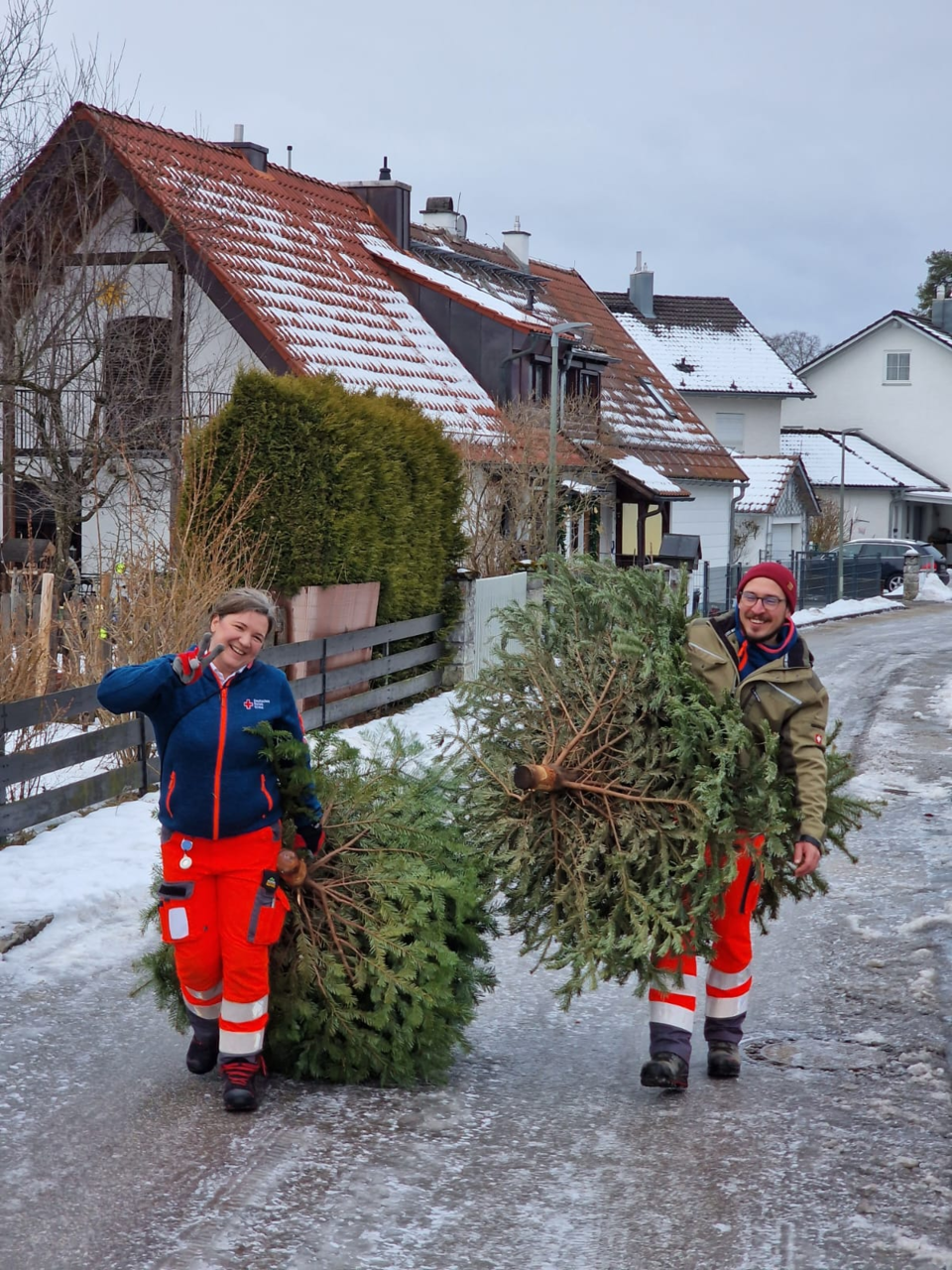 zwei Ehrenamtliche holen einen Christbaum und entsorgen diesen gegen eine kleine Spende